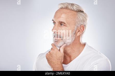 Visage, réflexion et homme senior en studio isolé sur fond gris maquette. Les soins de la peau, les cosmétiques et les hommes âgés retraités perdus dans les pensées ou Banque D'Images