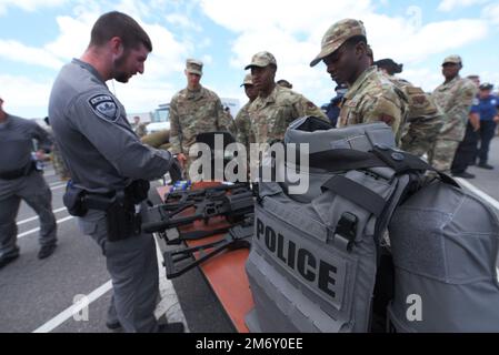 Les aviateurs américains avec la 325th Fighter Wing discutent avec un membre du SWAT de la police de Panama City lors d'une cérémonie d'ouverture de la semaine nationale de la police organisée par le 325th Security Forces Squadron à la base aérienne de Tyndall, Floride, le 9 mai 2022. Tyndall a rendu hommage à la semaine nationale de la police le 9-13 mai en encourageant les agents de la force publique à assister à des événements avec les agences locales d'application de la loi pour démontrer la nature collaborative de ceux qui servent dans la défense publique à travers le pays. ACC, Q-UGV, fusils, chien robot, équipe Tyndall, armes, Banque D'Images