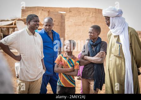 Un soldat de l'équipe des affaires civiles des Forces armées nigériennes (langue française : armées nigériennes - FAN), discute de la stabilisation du village et de l'avancement d'un précédent projet de restauration de l'eau avec le chef adjoint d'Alwat, Niger, 9 mai 2022. Ces réunions, facilitées par l’équipe des affaires civiles du Groupe expéditionnaire aérien de 409th, renforcent le partenariat du FAN avec les villages locaux, ce qui permet d’établir des liens solides et de garantir la continuité de l’engagement entre le gouvernement du Niger et ses citoyens. Banque D'Images