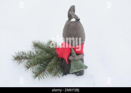 Lapin jouet noir comme symbole 2023 sur fond de neige blanc. Concept Noël et bonne année. Lapin chinois 2023 Banque D'Images