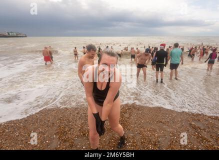 Des centaines de nageurs s'embattent dans une mer agitée le jour de Noël sur la plage de Brighton dans le cadre des festivités avec un plongeon revigorant. Brighton, Banque D'Images