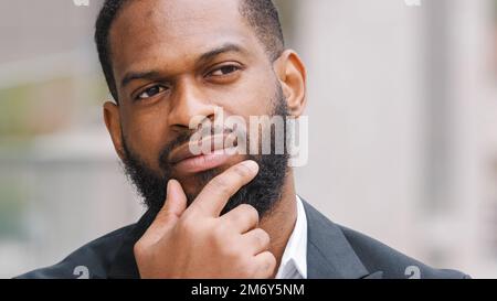 Pensive pensée réfléchie barbu Africain américain homme d'affaires ethnique homme d'affaires debout à l'extérieur pensez à l'idée de défi d'affaires Banque D'Images