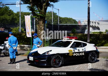 Des policiers japonais se tenant à côté de la voiture de police; Japon Banque D'Images