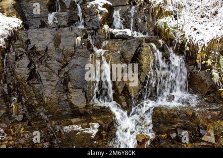 Ruisseau avec de l'eau sur des rochers en hiver Banque D'Images