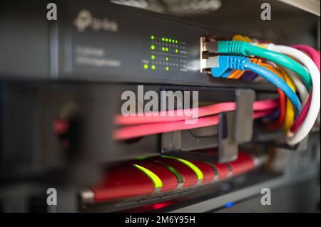 Routeur et commutateur avec des câbles LAN colorés dans une armoire réseau d'un centre de données Banque D'Images