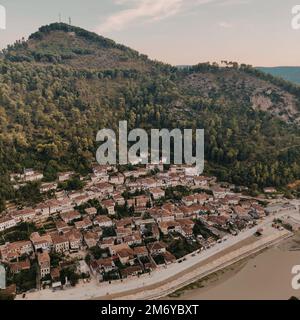 La petite ville avec des bâtiments et des arbres luxuriants sur la colline en arrière-plan Banque D'Images