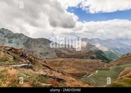 Сarpet de hautes montagnes alpines hautes hautes hautes hautes collines colorées au début de l'automne, rochers abrupts à l'horizon dans le parc national de Gran Paradiso, vallée d'Aoste, Italie Banque D'Images