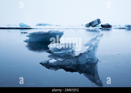Gros plan des roches de glace de l'Arctique et de leurs réflexions à la surface de l'eau gelée Banque D'Images