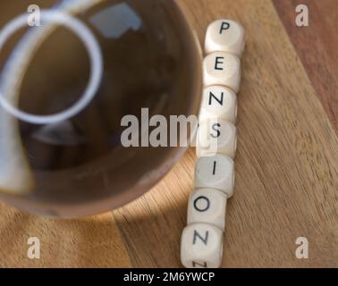 Une boule de cristal à côté d'une rangée de lettres en bloc qui énoncent le mot pension, l'avenir de la pension, le financement des retraités, la prévision future de la valeur de la pension Banque D'Images