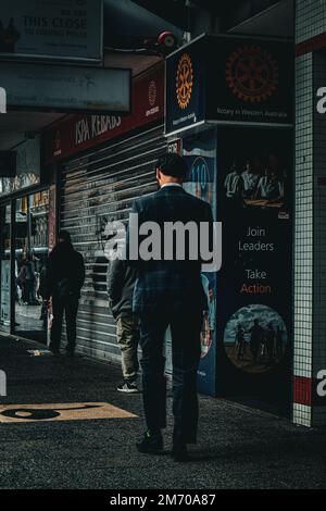 Un cliché vertical d'un homme en costume classique qui se promve dans le centre-ville de Perth, en Australie Banque D'Images