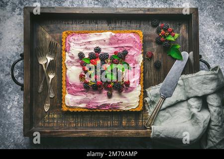 Gâteau au fromage BlackBerry avec baies sur plateau en bois avec fourchettes et couteau Banque D'Images