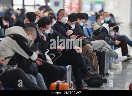 Les passagers portant des masques faciaux par mesure de précaution contre la propagation du covid-19 s'assoient dans la salle d'attente de la gare. Banque D'Images