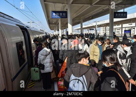Les passagers portant des masques faciaux contre la propagation du covid-19 transportent des sacs à dos et des valises à l'embarquement. Banque D'Images
