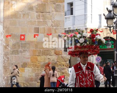 Tunis, Tunisie. 5th janvier 2023. Un homme avec des fleurs en plastique sur sa tête est photographié dans la Médina de Tunis, Tunisie, le 5 janvier 2023. POUR ALLER AVEC "Economic Watch: Les agents de voyage en Tunisie attendent des touristes chinois après l'optimisation de la Chine de la réponse de COVID-19" crédit: Xu Supei/Xinhua/Alay Live News Banque D'Images