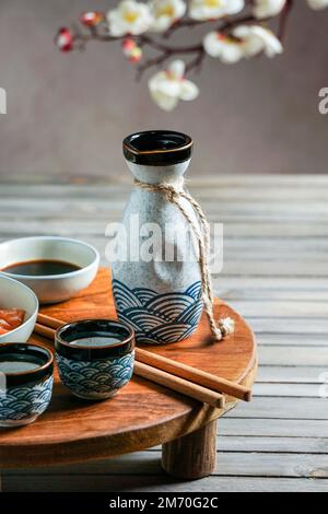 Saké japonais et saumon sashimi et algues wakame sur table en bois asiatique Banque D'Images