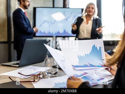 Femme d'affaires regardant une série de données et d'analyses au cours d'une réunion d'affaires, travailleur méconnaissable étudiant les tendances de l'investissement commercial Banque D'Images