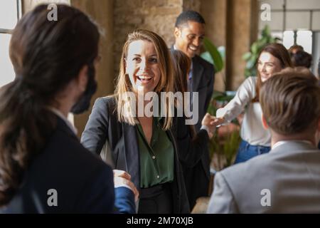 Femme d'affaires adulte mûre souriante se serrant la main avec un collègue lors d'une réunion avec des collègues, des gens d'affaires confiants et heureux saluent et co Banque D'Images