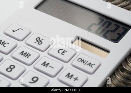 Une calculatrice blanche avec 2023 à l'écran. Un concept d'enregistrement des revenus, des dépenses et du contrôle des finances. Banque D'Images