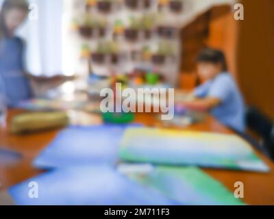 Un établissement d'enseignement artistique blut la texture bokeh. Un jeu d'enfant dans les cours d'art en personne, un arrière-plan flou. Banque D'Images