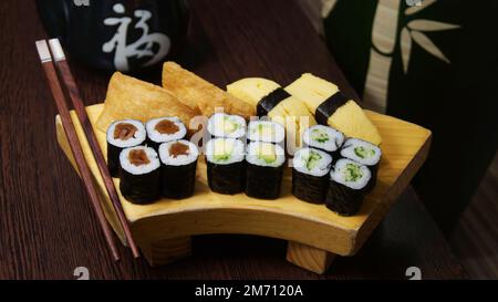 Ensemble de sushis avec une variété de makis, nigiris et sashimi avec des poissons fins comme le saumon et le thon. Banque D'Images