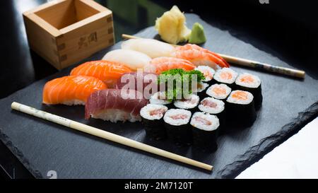 Ensemble de sushis avec une variété de makis, nigiris et sashimi avec des poissons fins comme le saumon et le thon. Banque D'Images