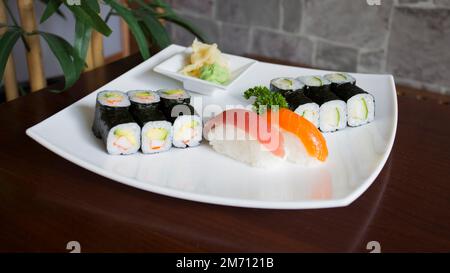 Ensemble de sushis avec une variété de makis, nigiris et sashimi avec des poissons fins comme le saumon et le thon. Banque D'Images