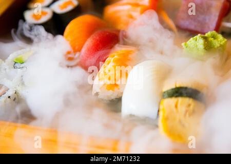 Ensemble de sushis avec une variété de makis, nigiris et sashimi avec des poissons fins comme le saumon et le thon. Banque D'Images