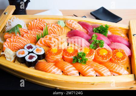 Ensemble de sushis avec une variété de makis, nigiris et sashimi avec des poissons fins comme le saumon et le thon. Banque D'Images