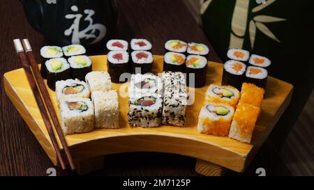 Ensemble de sushis avec une variété de makis, nigiris et sashimi avec des poissons fins comme le saumon et le thon. Banque D'Images