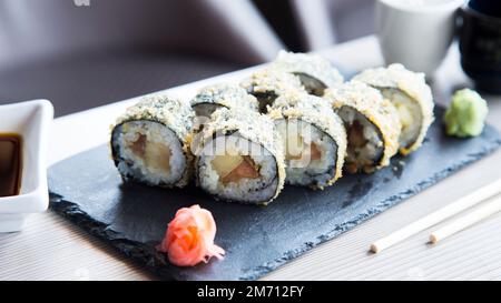 Rouleau chaud au saumon. Roulé à sushi farci de saumon et poêlé entier avec chapelure. Banque D'Images