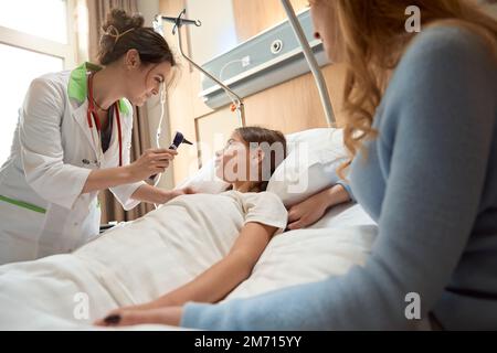 Le médecin tient l'otoscope dans ses mains pour examiner le canal auditif Banque D'Images