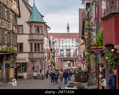 Maisons colorées à colombages et touristes dans la rue du général de Gaulle et en arrière-plan Hôtel de ville, Riquewihr, Reichenweier Banque D'Images