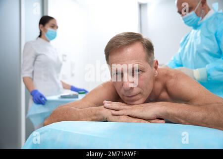 Un chirurgien expérimenté effectue des opérations peu invasives dans une salle lumineuse Banque D'Images