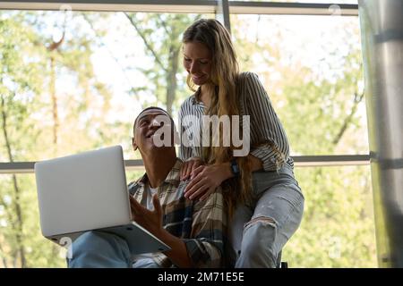 Un homme heureux tenant un ordinateur portable tout en regardant sa petite amie Banque D'Images