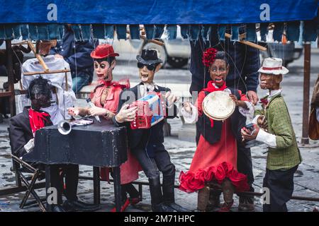 Vue sur le théâtre de spectacles de marionnettes de rue, avec le maître de marionnettes de marionnette tirant les ficelles sur différentes marionnettes Banque D'Images