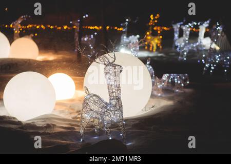 Décorations électriques dans une rue enneigée d'hiver, éclairage de nuit, Noël en Europe, avec lampes à rennes faites d'ampoules et de fil Banque D'Images