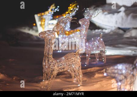 Décorations électriques dans une rue enneigée d'hiver, éclairage de nuit, Noël en Europe, avec lampes à rennes faites d'ampoules et de fil Banque D'Images