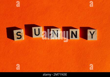 plan de cubes en bois avec des lettres sur une surface orange. Mot soleil Banque D'Images