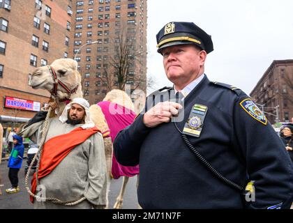New York, États-Unis. 6th janvier 2023. Un policier qui garde un œil sur la foule marche à côté d'un participant qui mène un chameau dans Third Avenue pendant la parade annuelle de trois Kings Day Parade 46th organisée par El Museo del Bario. La célébration traditionnelle espagnole a eu lieu en personne pour la première fois depuis le début de la pandémie du coronavirus (COVID-19). Le thème de cette année était : « entre Familia: Santé mentale et bien-être de nos communautés », axé sur l'importance de la santé mentale et du bien-être. Credit: Enrique Shore/Alay Live News Banque D'Images