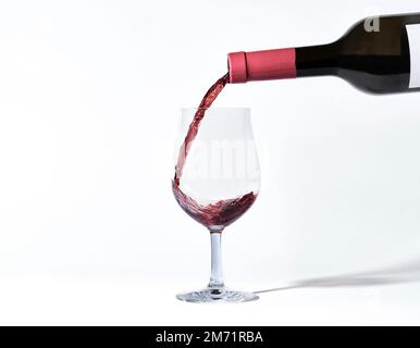 Verre de vin. mettez dans le vin rouge. Bouteilles et verres de vin. Culture de manger et de boire. Boissons alcoolisées. Prise de vue isolée sur fond blanc. Banque D'Images