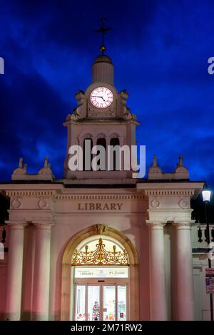 Tour d'horloge lumineuse ornée au-dessus d'une bibliothèque publique au crépuscule à Saffron Walden Banque D'Images