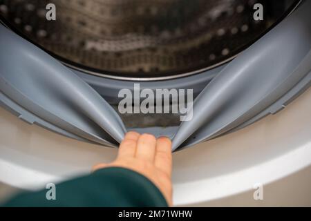 Moisissure dans le caoutchouc autour de la machine à laver, mauvaise odeur. moule dans le joint en caoutchouc dans une machine à laver. Caoutchouc d'étanchéité pour lave-linge moddy sale Banque D'Images