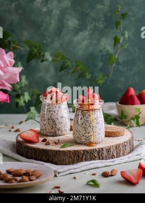 Le lait de Chia et Oats aux amandes, aux fraises et au miel sur une base rustique et une serviette Banque D'Images