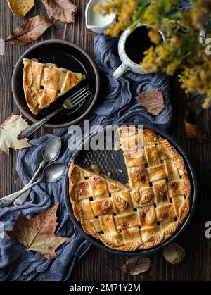 Tarte aux pommes dans un moule sur une table rustique d'automne Banque D'Images