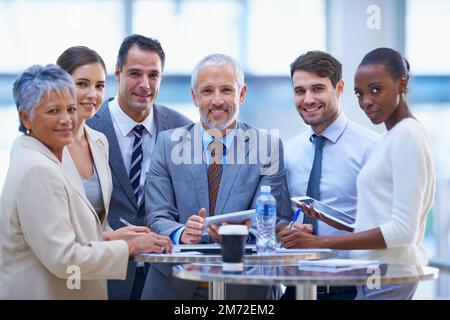 Cette entreprise prend le dessus. Portrait d'une équipe de gens d'affaires heureux assis ensemble à une réunion. Banque D'Images