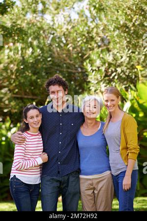 Visite de Grandma. Portrait d'une famille heureuse de plusieurs générations debout ensemble dans un jardin. Banque D'Images