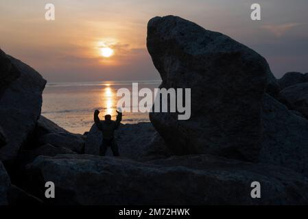 Hulk, le héros de la bande dessinée jouet était situé sur la plage rocheuse pendant l'heure du coucher du soleil Banque D'Images