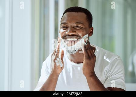 Rasage, crème et visage noir pour homme pour un look impeccable, des soins d'hygiène et de beauté dans la salle de bains. Soin de la peau, heureux et Africain Banque D'Images