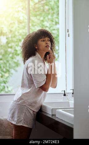 Femme noire, bouton d'acné et matin dans la salle de bains pour commencer, soin de la peau et beauté du visage dans la maison. Gen z femme, la santé de la peau du visage et les mains pour zit Banque D'Images