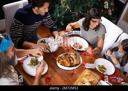 Cette blague est un peu plus difficile à lire. une famille attend pour entendre les petites filles de noël cracker blague. Banque D'Images